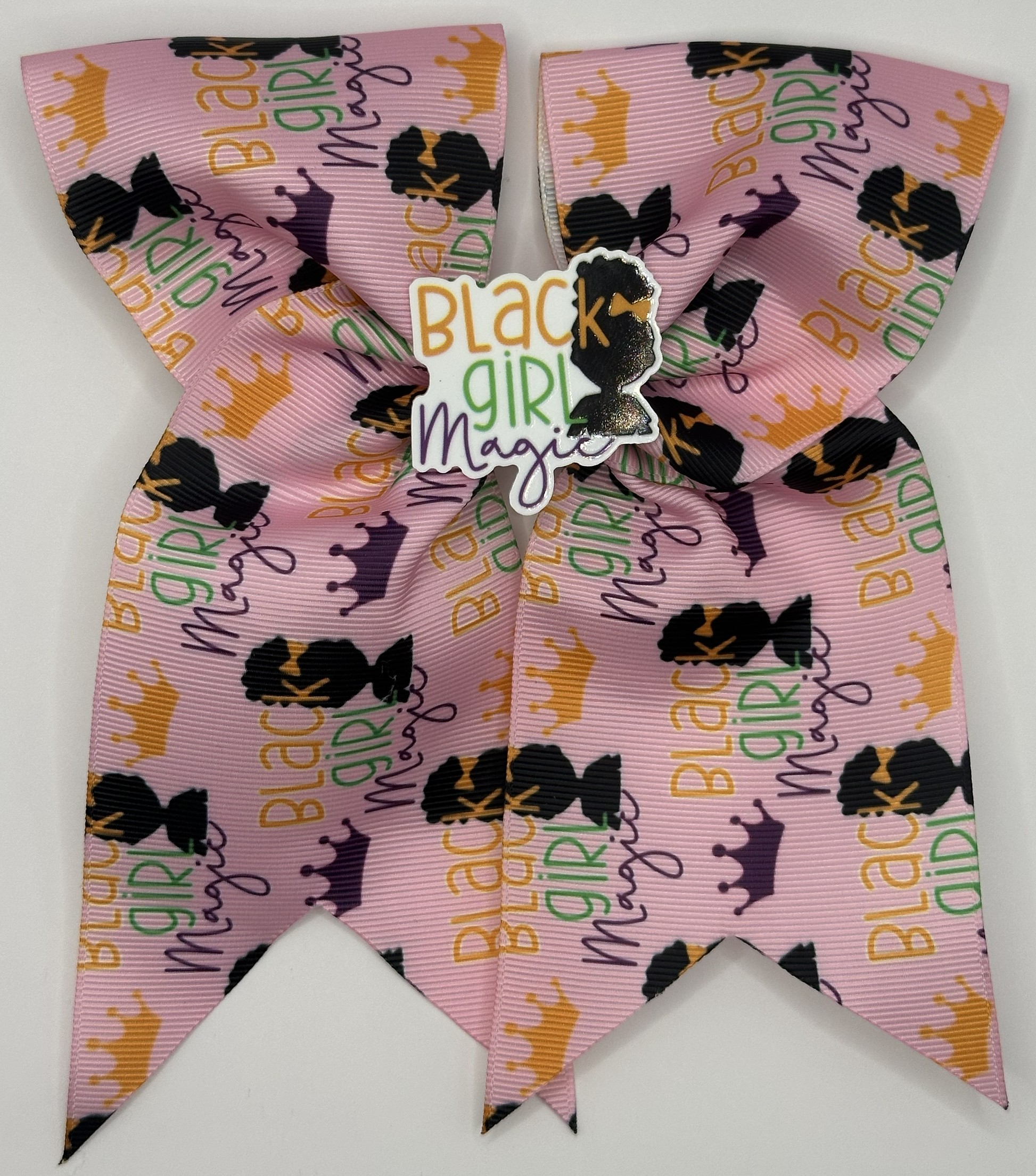 Pink hair bow with 'Black Girl Magic' text and crowns on a white background
