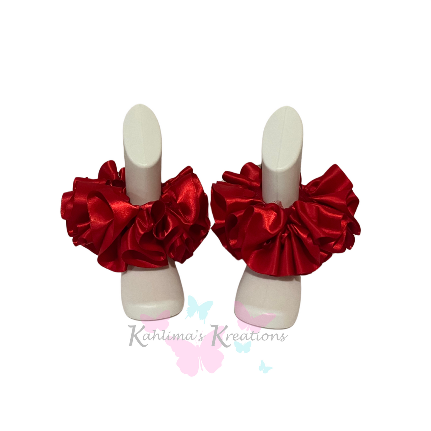 Pair of red ruffled anklets on white background