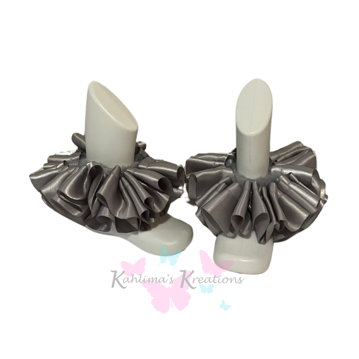 Pair of silver ruffled anklets on white background